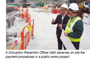 A Corruption Prevention Officer (left) observing on site the payment procedures in a public works project.