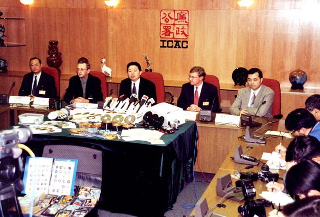 Mr Chu (centre) hosts a press briefing after an ICAC operation