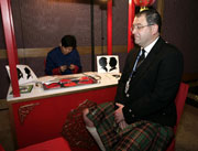 An overseas delegate has his silhouette cut out on paper prior to the dinner.